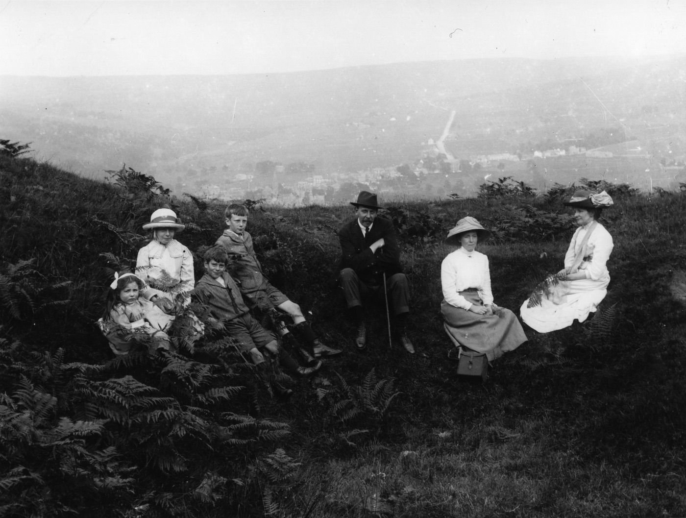 Coll. AMHS. Modern photographic print from a glass plate. This is by Hugh Walton of Alston, (HWA). His daughter May is at the far L and his wife, Isobel to the far R. Thev’ve climbed up Park Fell, leaving Alston & the road to Nenthead far below.