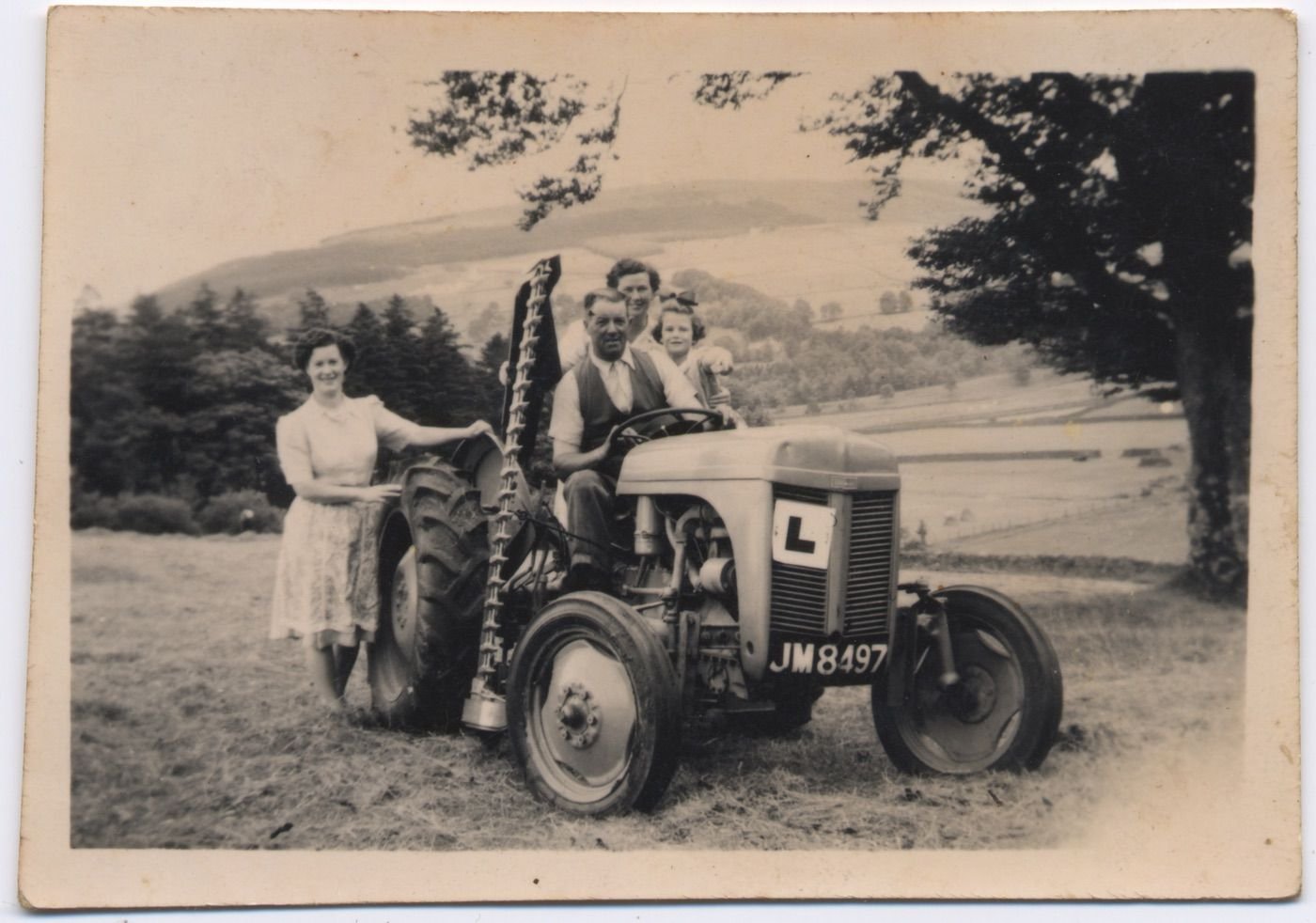 Coll. Paul MacMillan, Low Park.
Bob MacMillan on a tractor he "couldn't drive"- a ca 1949 grey Fergie with mid mounted mower. He mowed into his wife's leg with it once- more a hoss man! (Audio Paul MacMillan- "Fergie Tractor" )
At the back wheel, Dorothy  Guilder nee MacMillan  Pic from 1951